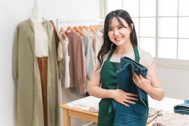shop attendant folding jeans at a boutique